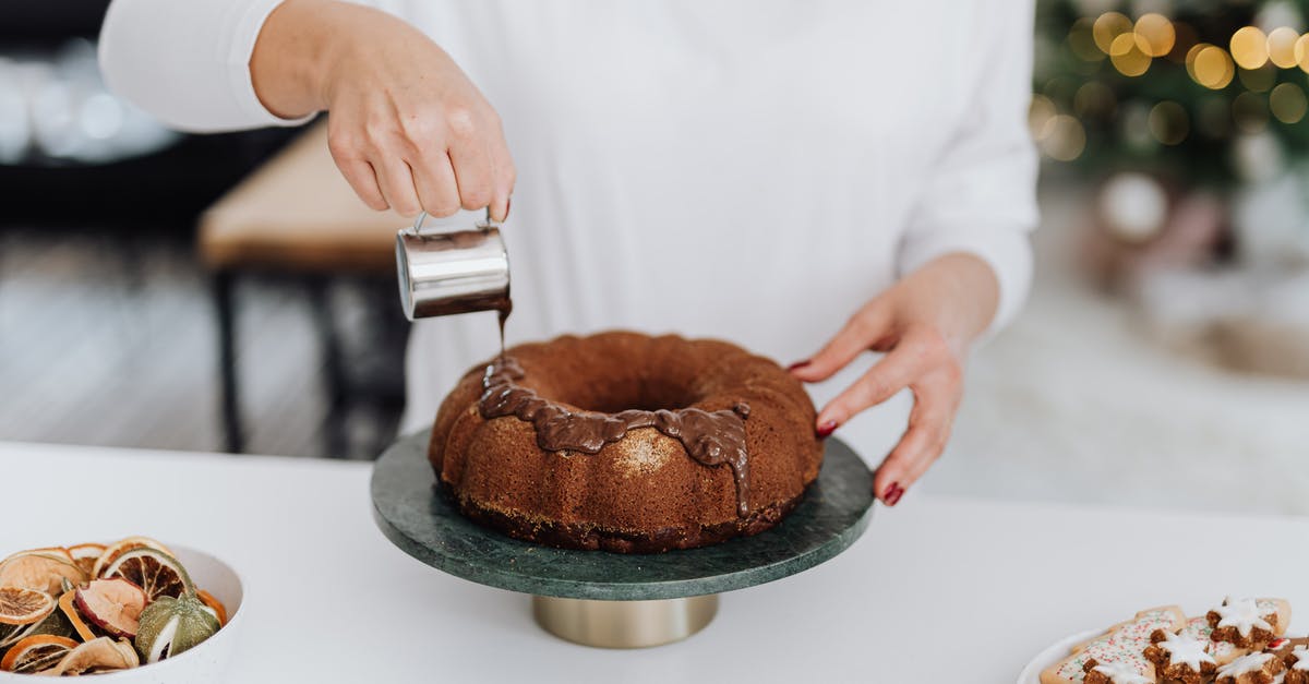 How can you speed up a genoise cake mixing? - Person in White Dress Shirt Holding Brown Round Cake