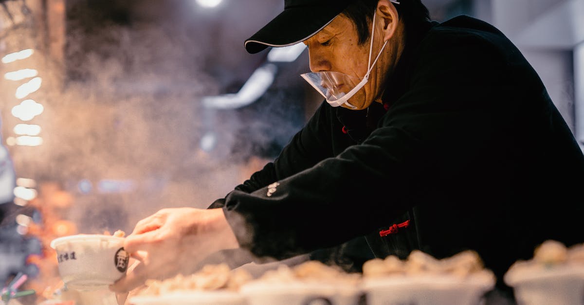 How could I cook industry like foie gras? - Man in Black Jacket and Black Hat Holding White Plastic Cups With Food