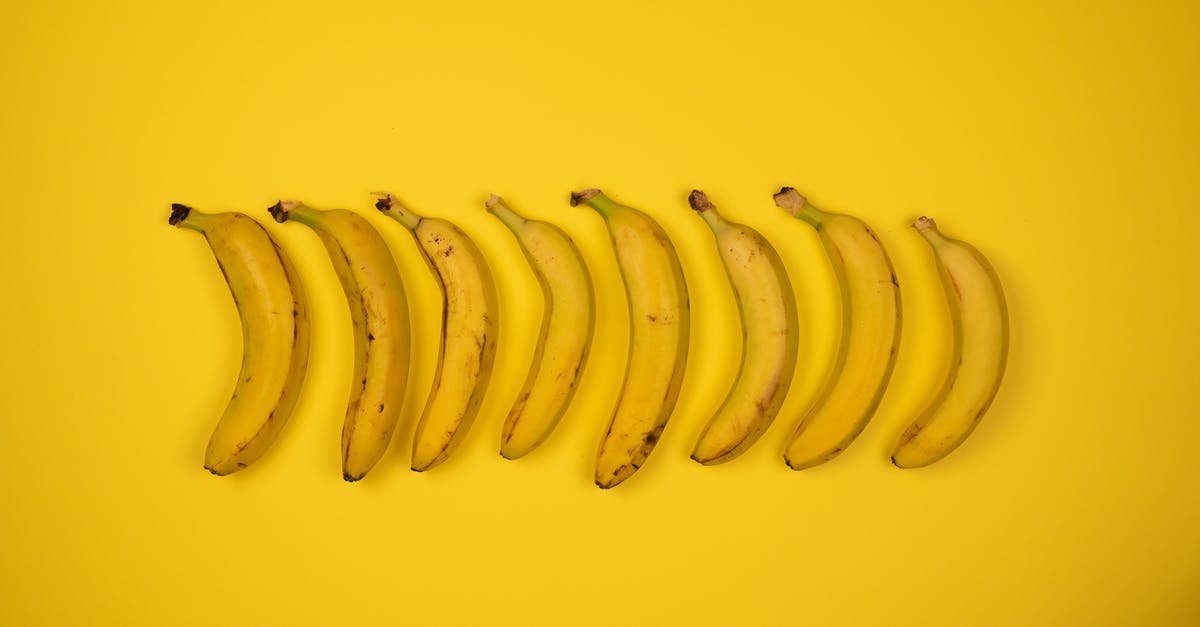 How deeply should I peel sweet potatoes? - Top view of tasty ripe bananas with blots on peel composed in row on yellow background