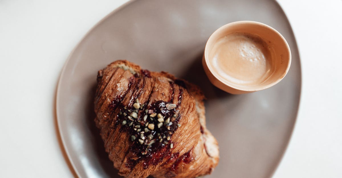 How do bakeries get smooth jam to top their cheesecakes with? - Cup of coffee and delicious croissant placed in plate