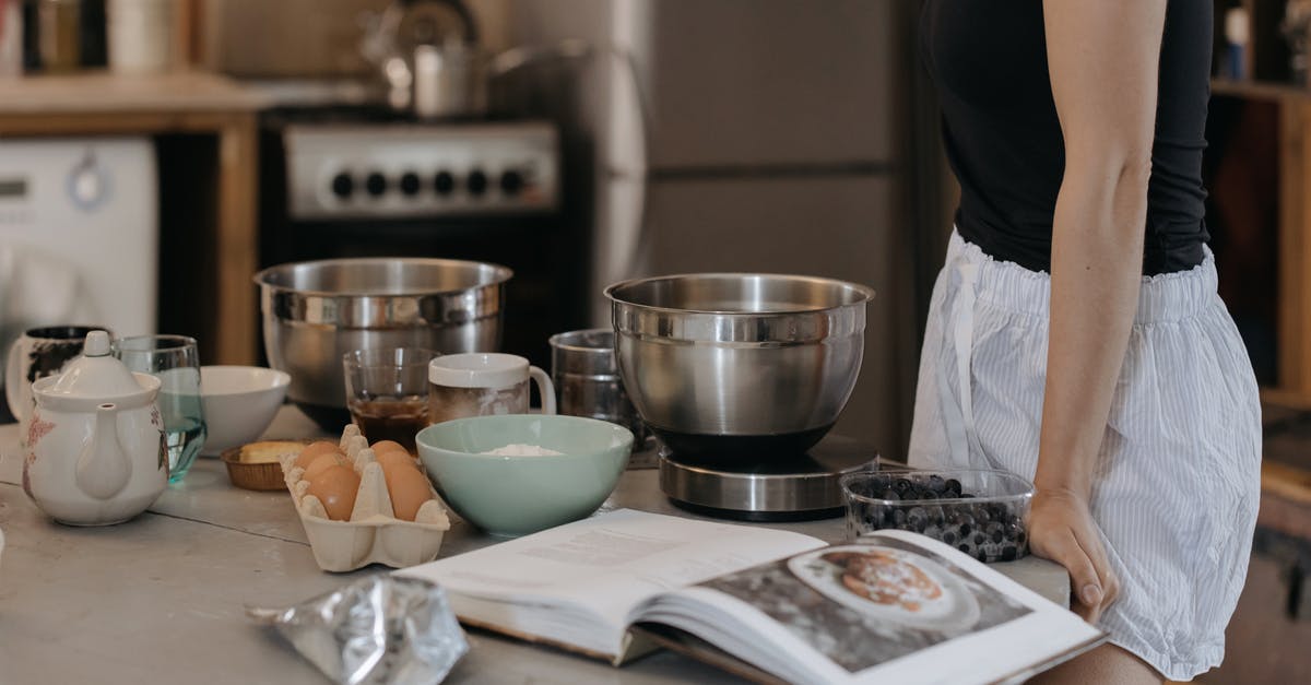 How do chefs come up with recipes for good food? - Woman in Black Shirt Standing in Front of Table With Bowls