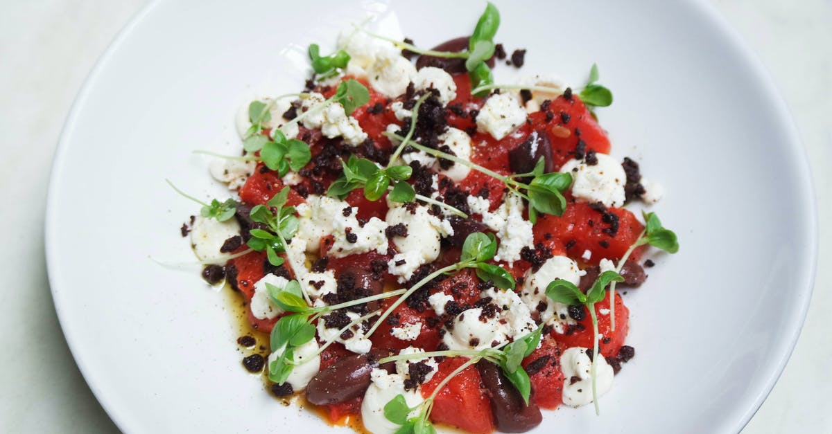 How do commercial sauce makers have such red tomato paste? - High angle of delicious vegetarian salad with fresh basil and beans with red pepper and eggs with sauce on white plate at table in restaurant