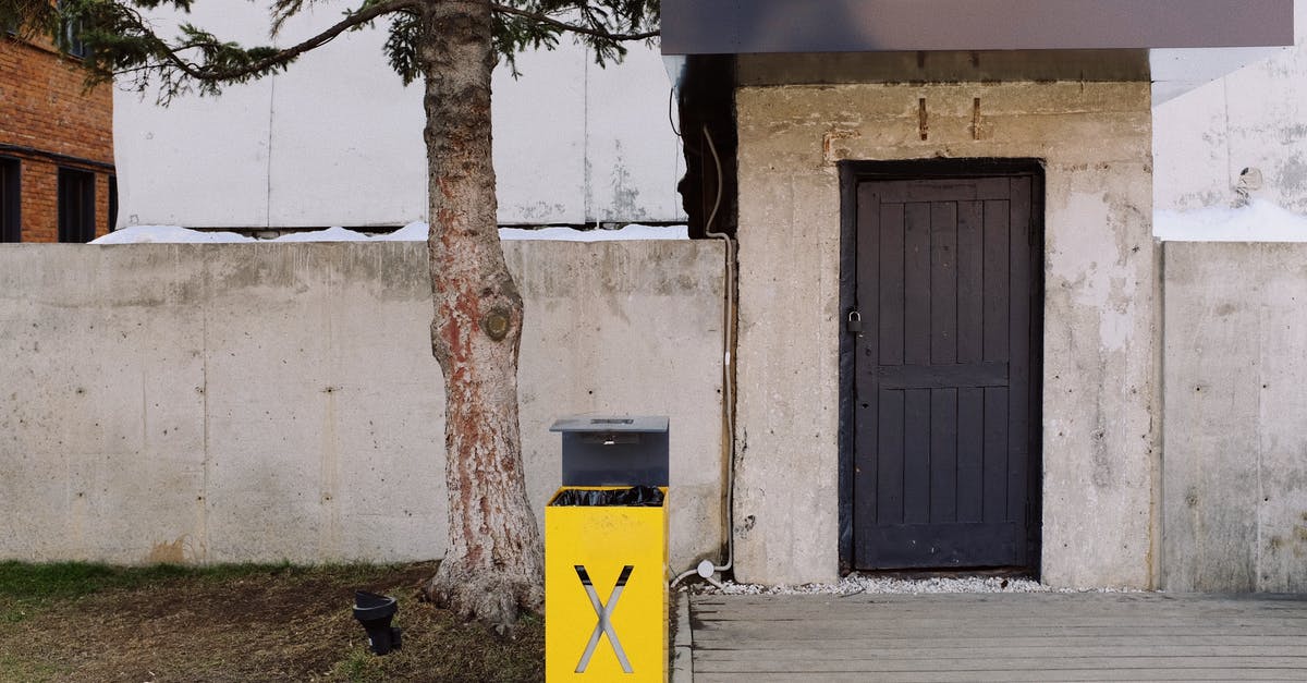 How do I care for a carbon steel knife? - Yellow metal trash bin placed under tree near entrance of building