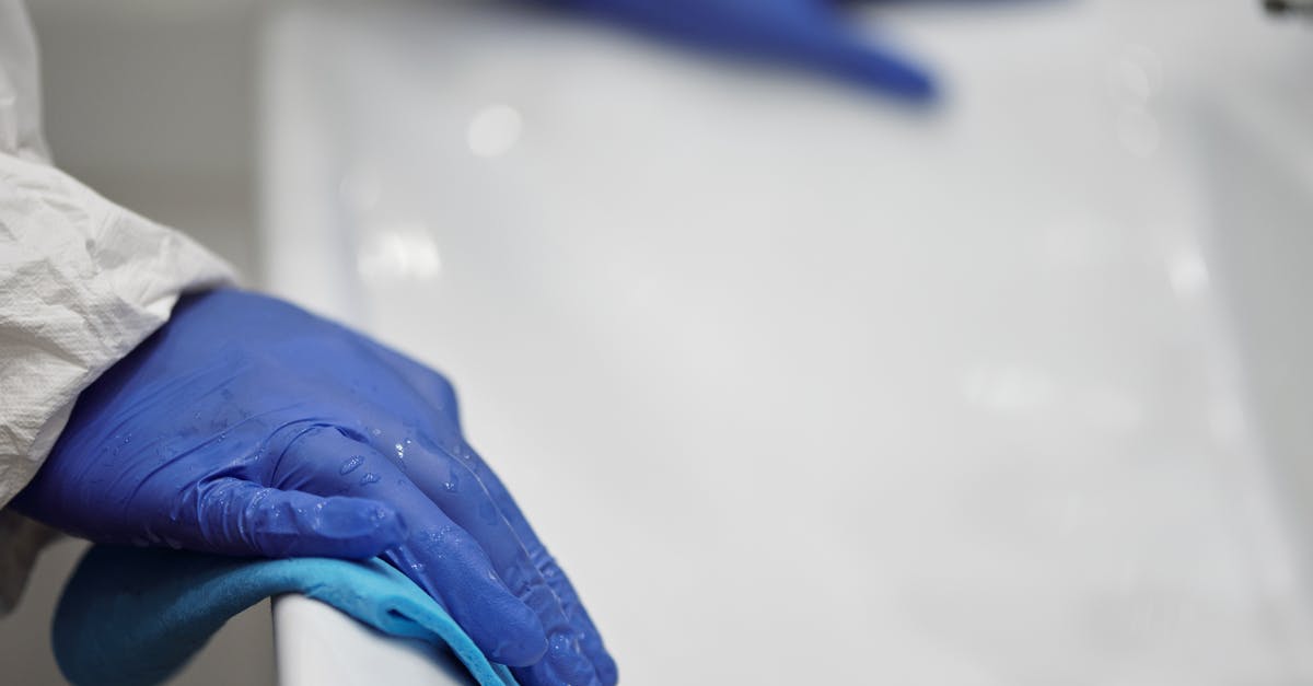 How do I clean these gloves so they do not leave marks? - Person in Blue Gloves Cleaning White Sink How do I clean these gloves so they do not leave marks? - Person in Blue Gloves Cleaning White Sink