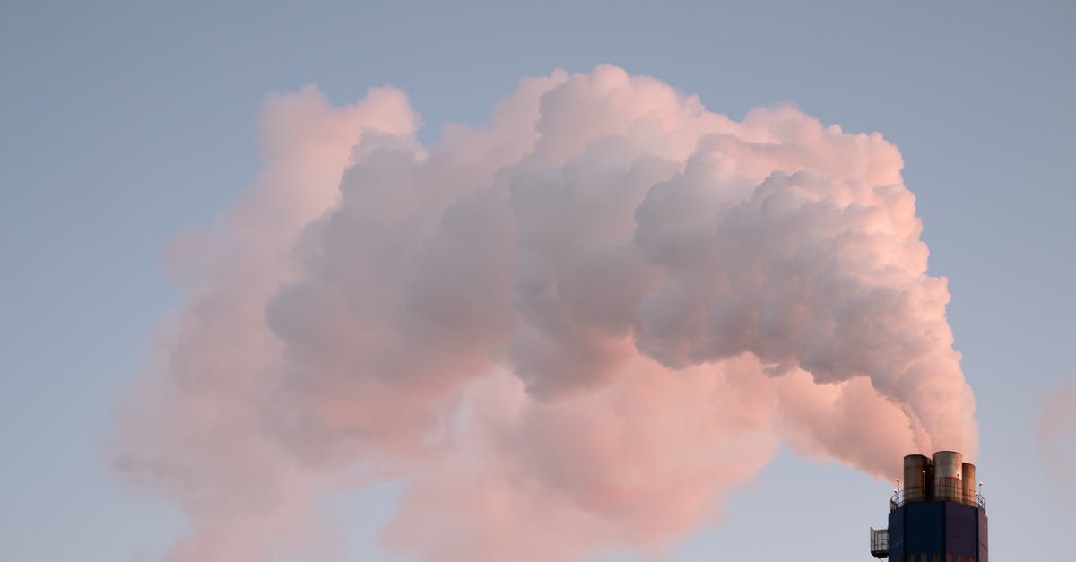 How do I control the smoke from a chimney starter? - From below of clouds of smoke from industrial factory pipes polluting atmosphere against cloudless sky