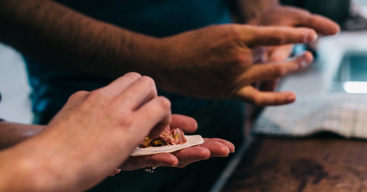 How do I cook minced meat faster? - Crop cooks preparing dumplings at table in kitchen