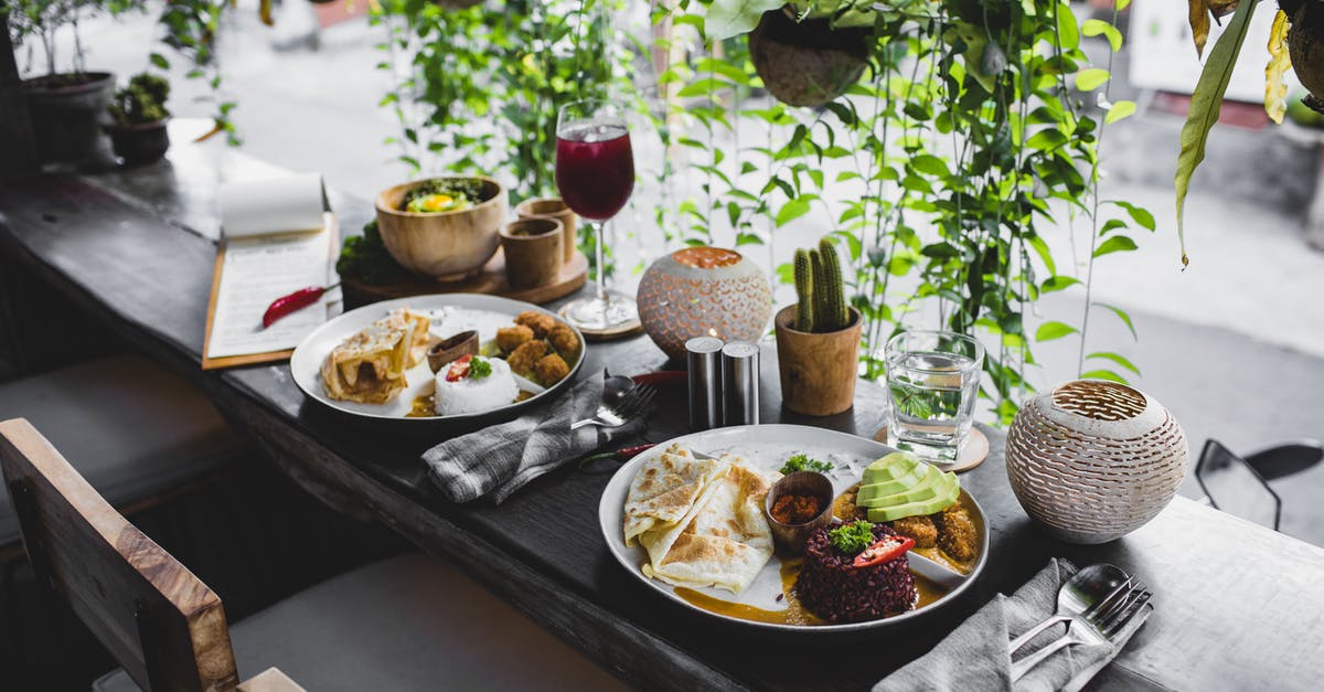 How do I cook store-bought glutinous rice dumplings? - High angle of plates with assorted healthy dishes served on wooden table with cutlery and drinks in stylish tropical cafe