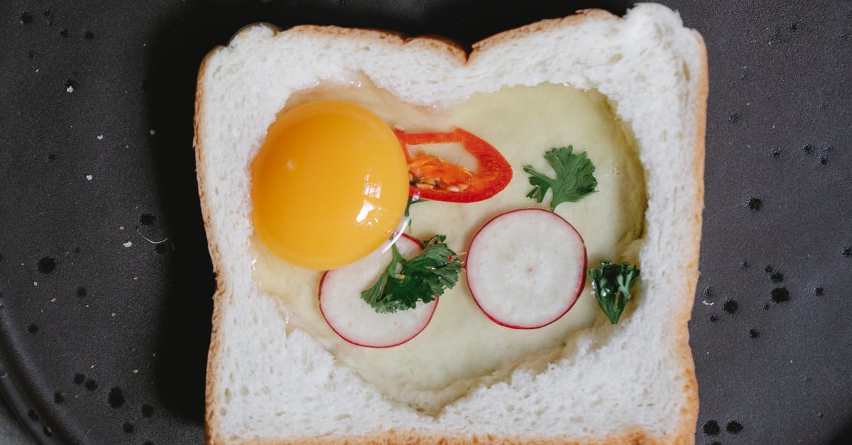 How do I cook toast on an Aga? - Top view yummy raw egg toast with white bread reddish and chili pepper placed on pan