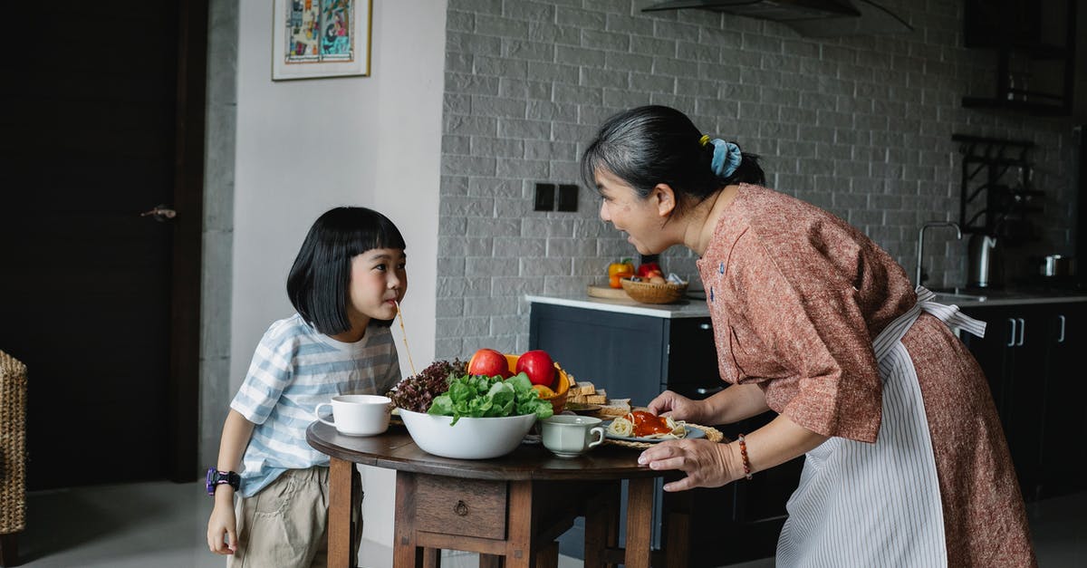 How do I cook toast on an Aga? - Happy woman with little girl preparing healthy lunch