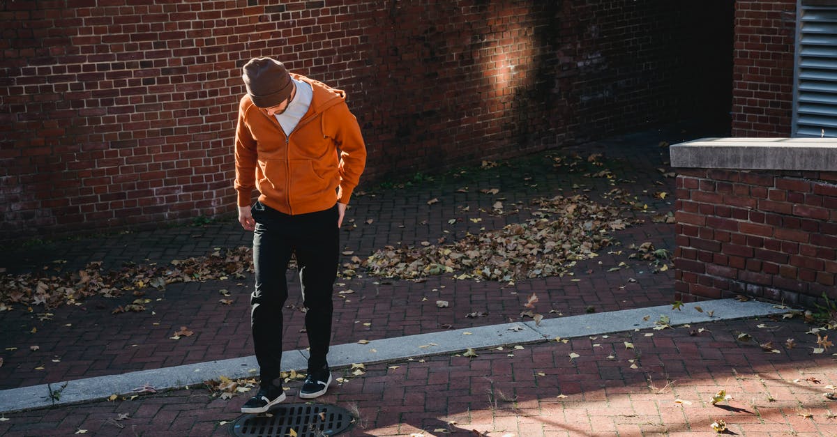 How do I drain sauerkraut? - Faceless man standing on street near at road drain