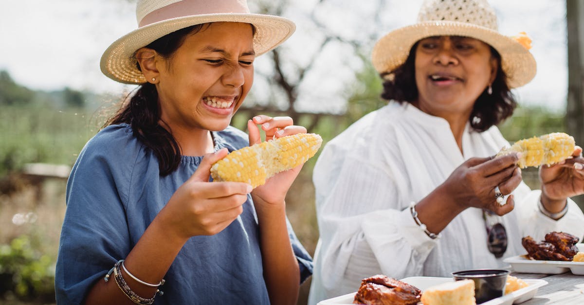 How do I eliminate Corn Meal "grittiness"? - Ethnic funny girl eating with mother in backyard