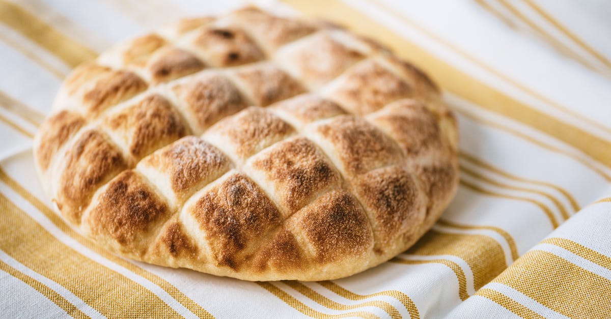 How do I get crispy but thin bread crust? - From above of tasty homemade bread loaf on table with fabric linen tablecloth