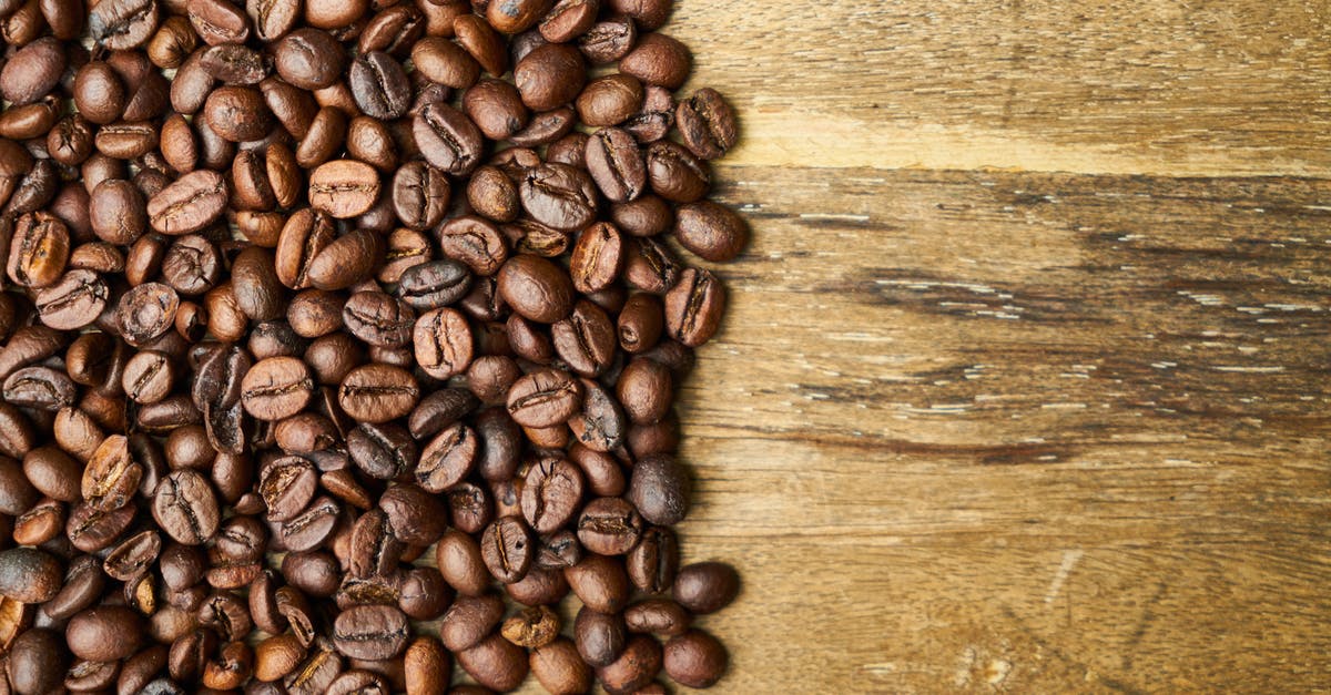 How do I infuse cappuccino with real vanilla bean during brew? - Top view of shiny aromatic roasted coffee beans scattered on rustic wooden table