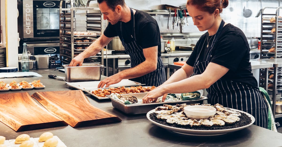 How do I know when my stock is done cooking? - Man and Woman Wearing Black and White Striped Aprons Cooking