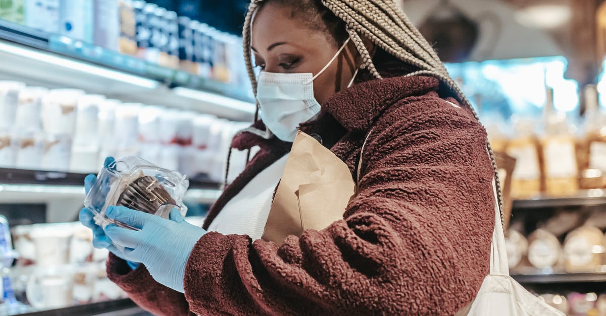 How do I label already-frozen bags? - Black female shopper reading label on food in supermarket