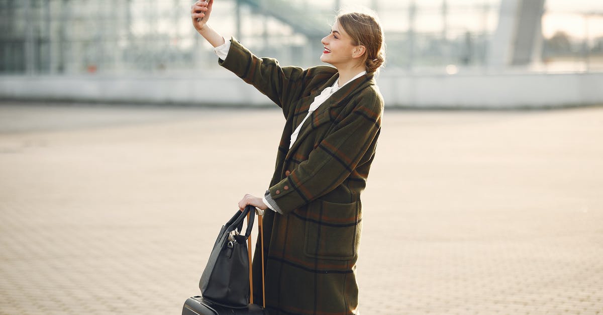 How do I make large spheres using spherification? - Stylish young woman with luggage taking selfie outside modern glass building