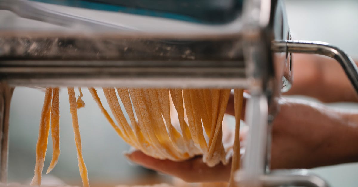 How do I make Pad See Ew with Fresh Rice Noodles - Crop anonymous female making fresh thin noodle while cutting dough in pasta machine