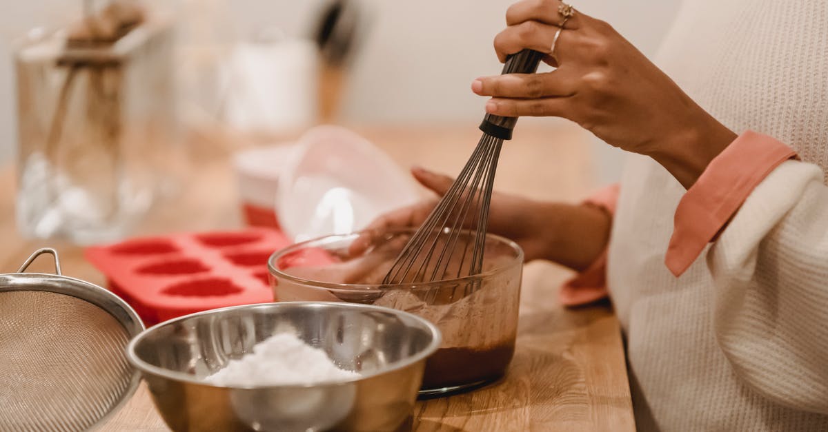 How do I melt the chocolate in a s'more? - Side view of crop anonymous African American female whisking melted chocolate near metal bowl with flour in kitchen