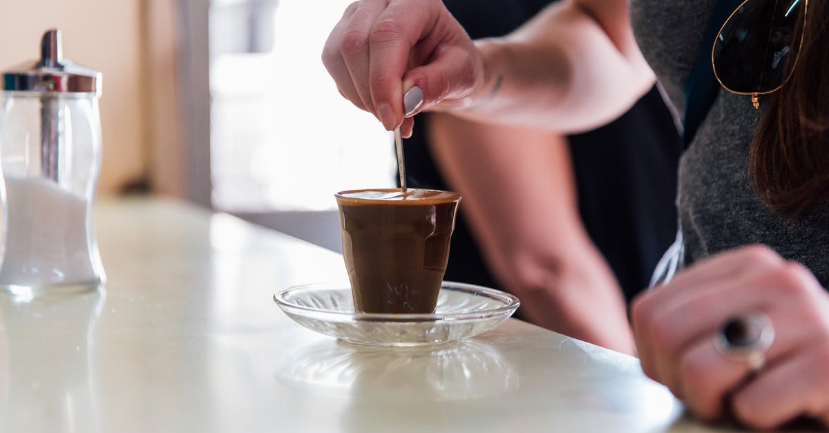 How do I mimic trader Joe's (dark) Chocolate covered Espresso Beans? - Person Stiring Brown Liquid in Clear Drinking Glass