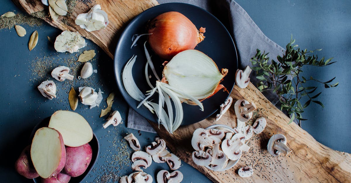 How do I prepare ash bolete mushrooms for recipes? - From above of chopped mushrooms scattered on table near plates with fresh onions and sweet potatoes