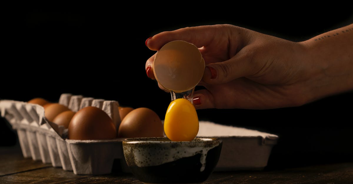 How do I prevent an egg cracking while hard boiling it? - Person Cracking an Egg on a Bowl