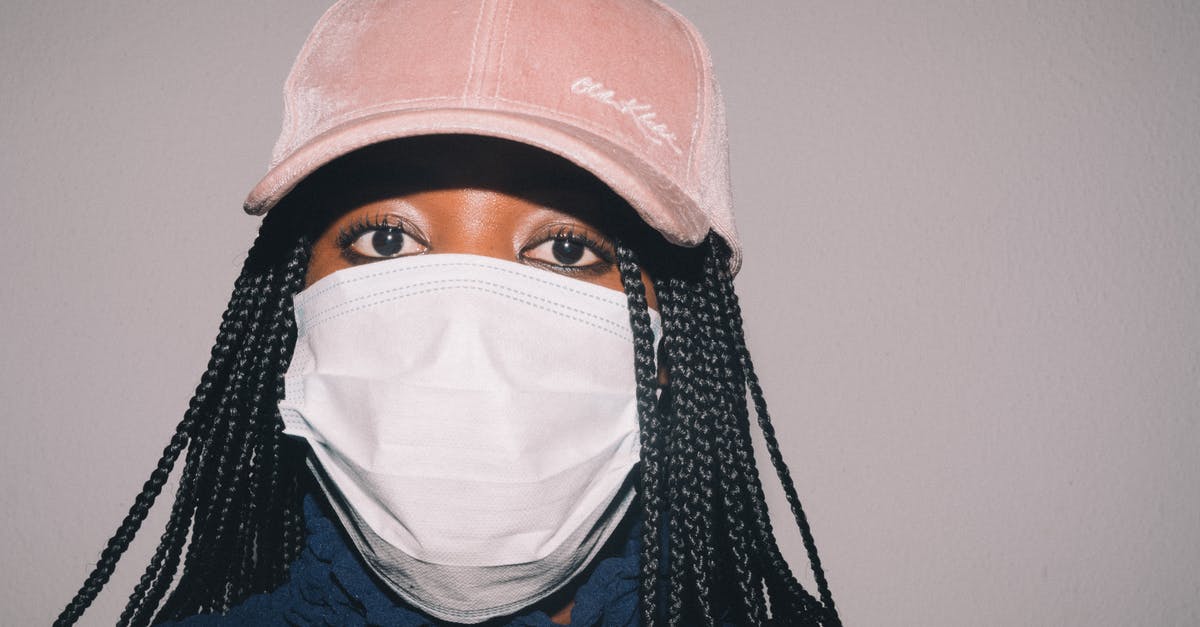 How do I prevent fudge browning? - Adult African American woman in casual clothes and pink cap and medical mask while standing against gray background