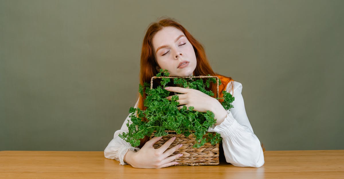 How do I properly cut leafy herbs like basil? - A Woman Grasping a Basket of Parsley