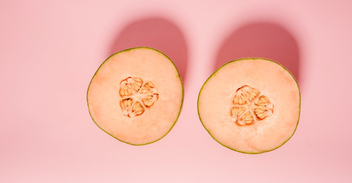 How do I remove bitterness from bitter melon - Top view of ripe orange melon cut into halves for healthy diet placed on pink background in modern light studio