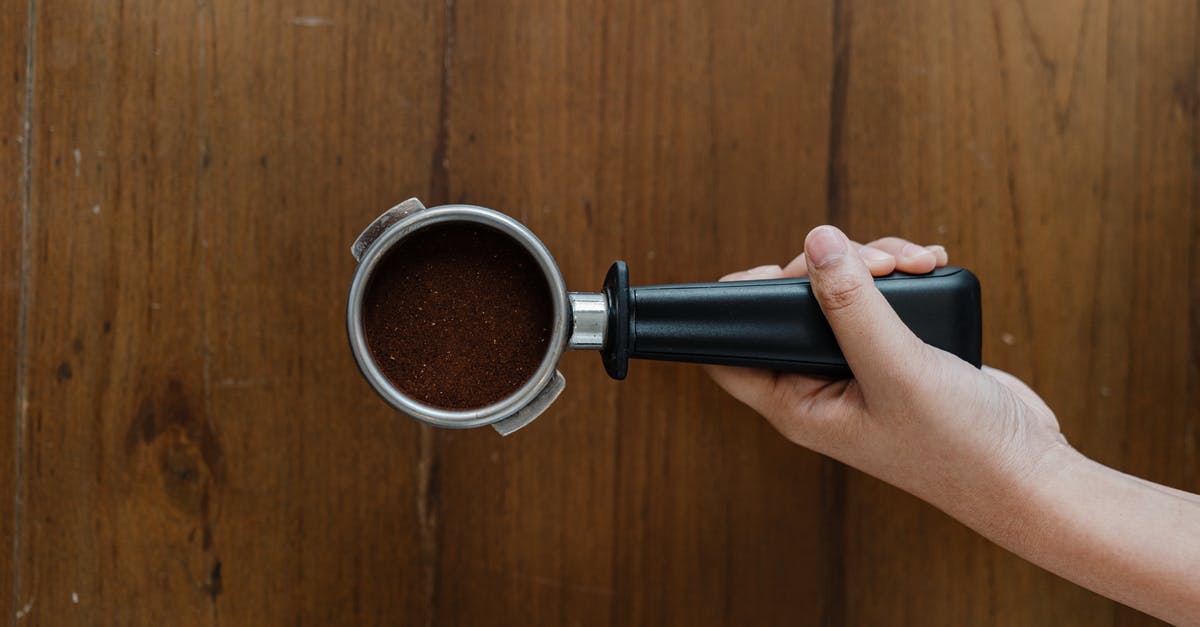 How do I remove boar taint (from a wooden handle)? - Crop person putting portafilter on wooden table