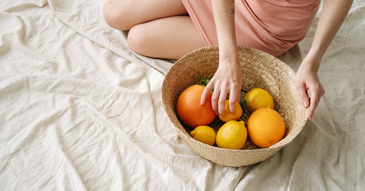 How do I ripen unripe oranges and grapefruits? - A Woman Holding a Basket with Citrus Fruits