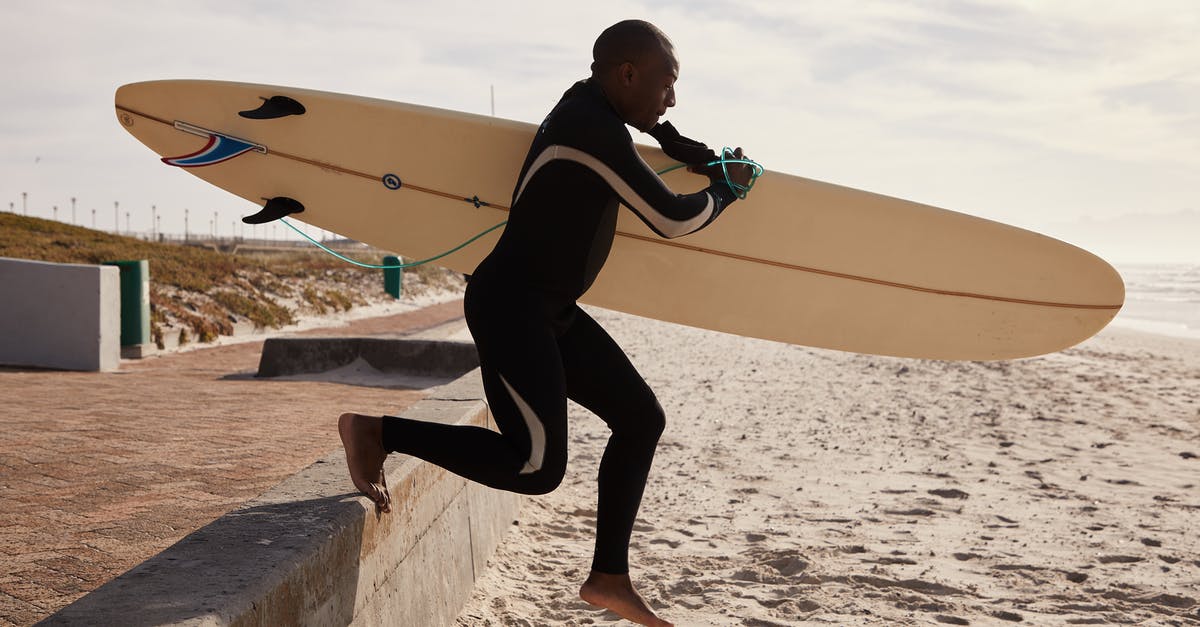 How do I trap lateral bones that run down outside edge? - Black surfer running to ocean with surfboard in daytime