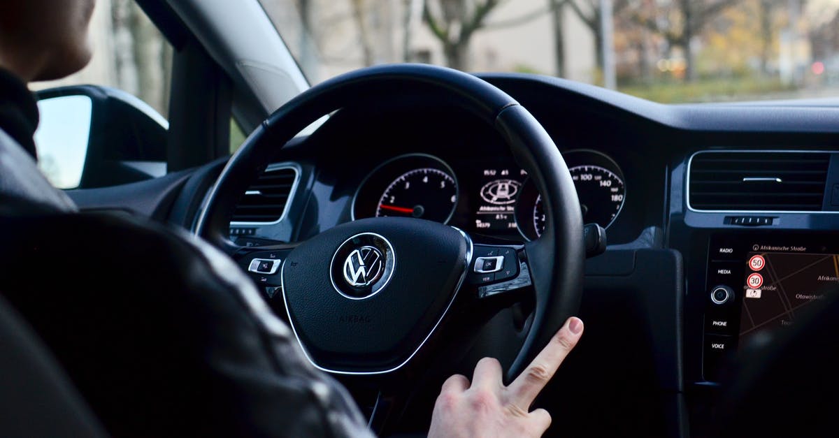 How do I turn on an auto ignition stove? - Back view of crop anonymous male driving contemporary transport while turning steering wheel in daylight