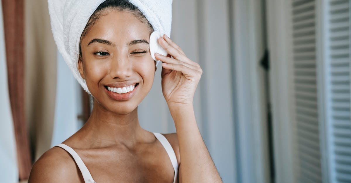 How do I wash farm-fresh eggs? - Smiling ethnic woman wiping face skin in morning