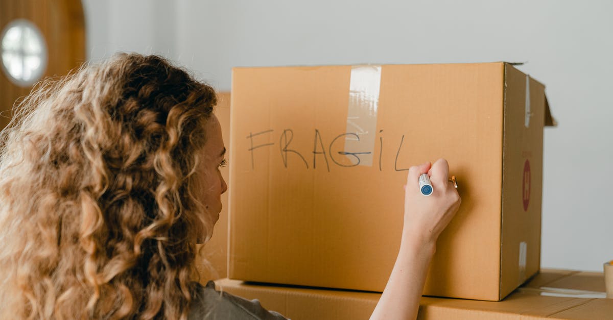 How do I wash the "pokey" side of a box grater? - Back view of unrecognizable curvy female in casual clothes writing fragile on empty side of carton box while waiting for courier