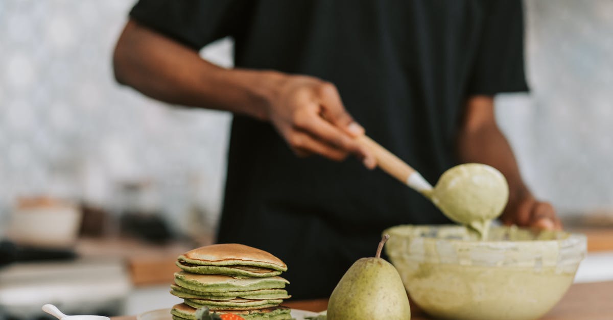 How do the batter and technique differ between crepes and pancakes? - A Person Mixing Batter in a Bowl