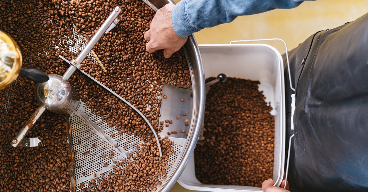 How do they get caffeine out in decaffeinated coffee? - A Person Holding a Bucket while Getting Coffee Beans From the Machine