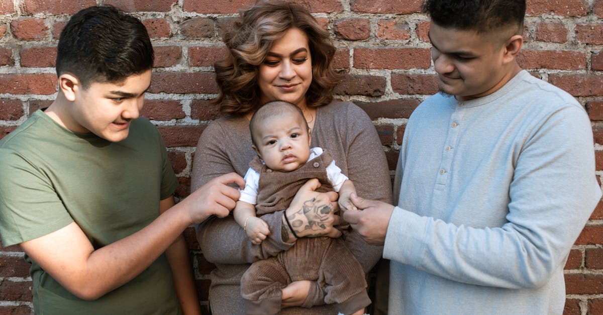 How do they make Mexican vanilla extract? - A Woman Carrying Her Baby Boy while Standing Between the Father and His Son