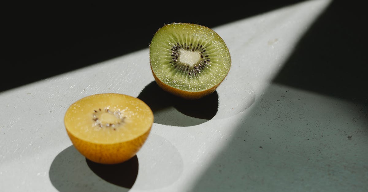 How do tomatillos differ in taste from under-ripe tomatoes? - Sliced ripe green and yellow kiwi on table