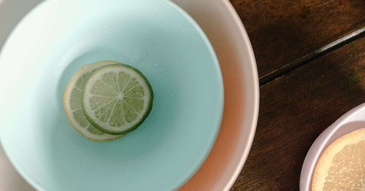 How do tomatillos differ in taste from under-ripe tomatoes? - Bowls with sliced lemon and lime