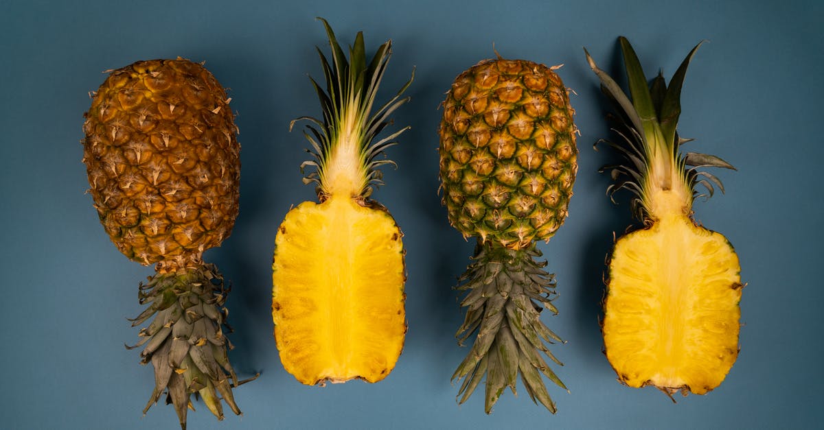 How do you barbeque a whole piece of fish? - Top view of fresh whole and cut pineapples with green leaves and yellow flesh with pleasant aroma