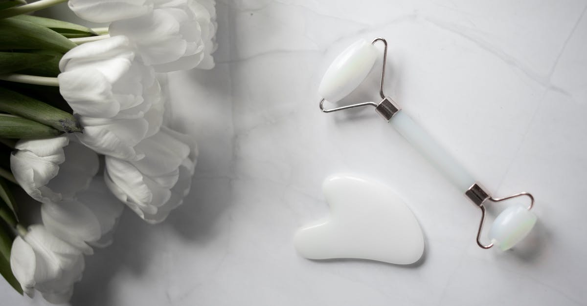 How do you clean a pizza stone? - White Gua sha tools placed near bouquet of flowers on marble table