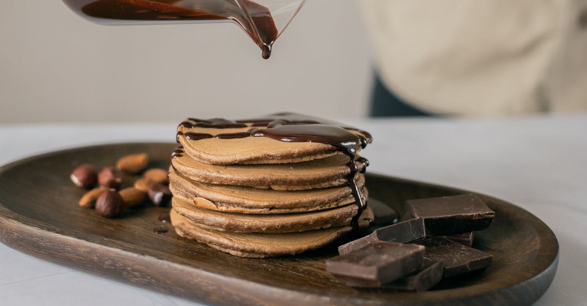 How do you cook margarine with brown sugar without separating? - Fresh appetizing pancakes poured with hot chocolate on wooden board