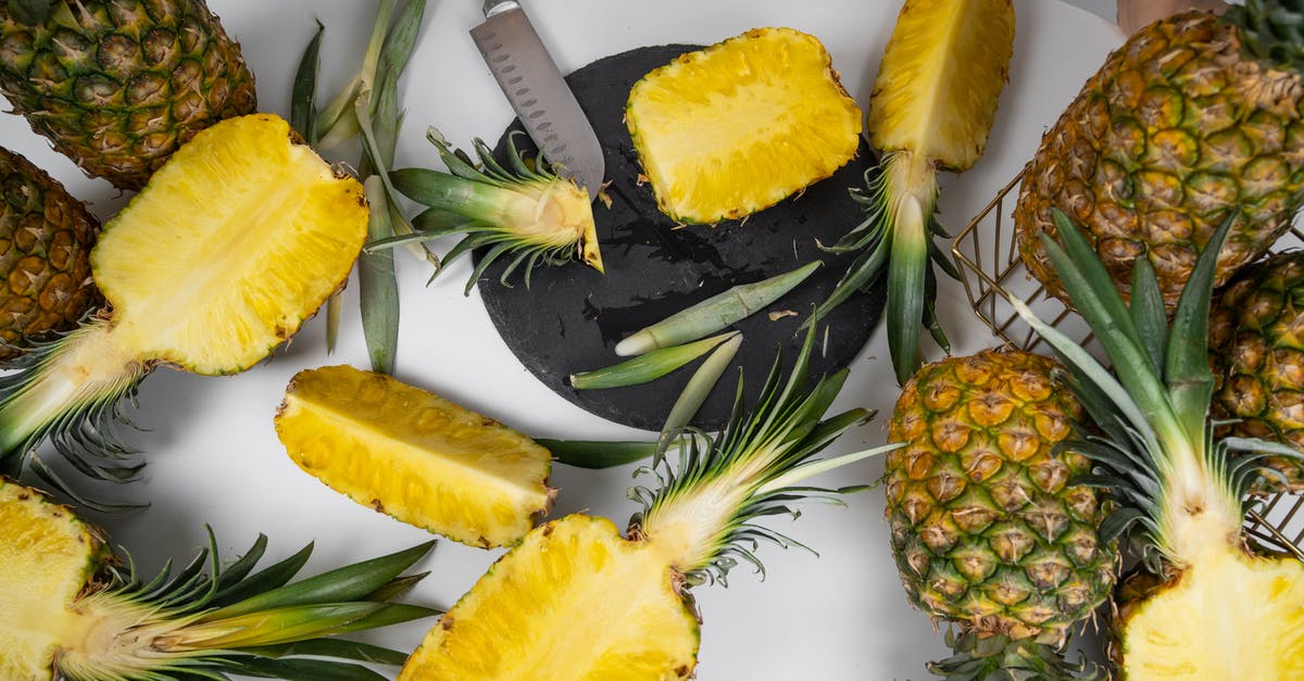 How do you cut/process a whole pineapple? - Ripe pineapples on table with knife in kitchen