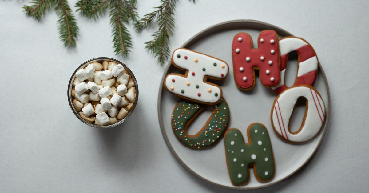 How do you form Marshmallow Ropes? - Overhead view of tasty biscuits in form of letters with decor near hot drink with marshmallows and fir sprig during New Year holiday