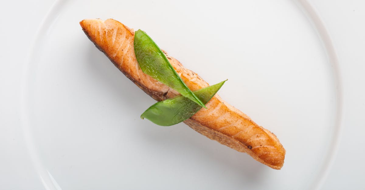 How do you fry a fat, uneven salmon filet? - Cooked Fish With Two Green Leaf on Round White Ceramic Plate