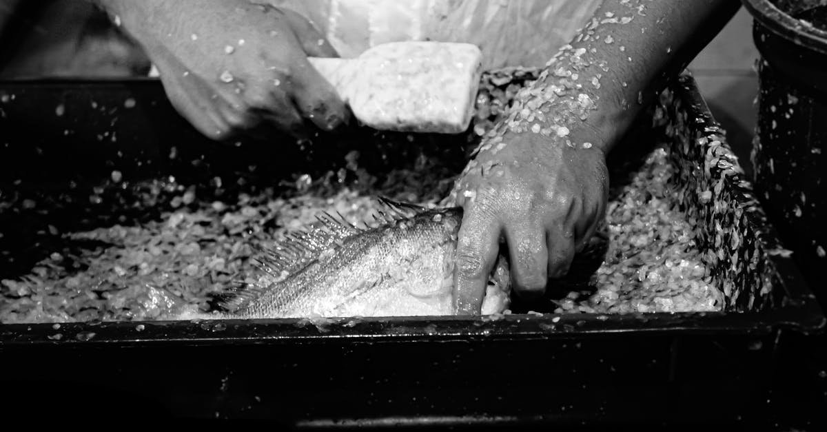 How do you get the smell of fish off your hands? - Person Holding Gray Concrete Stone