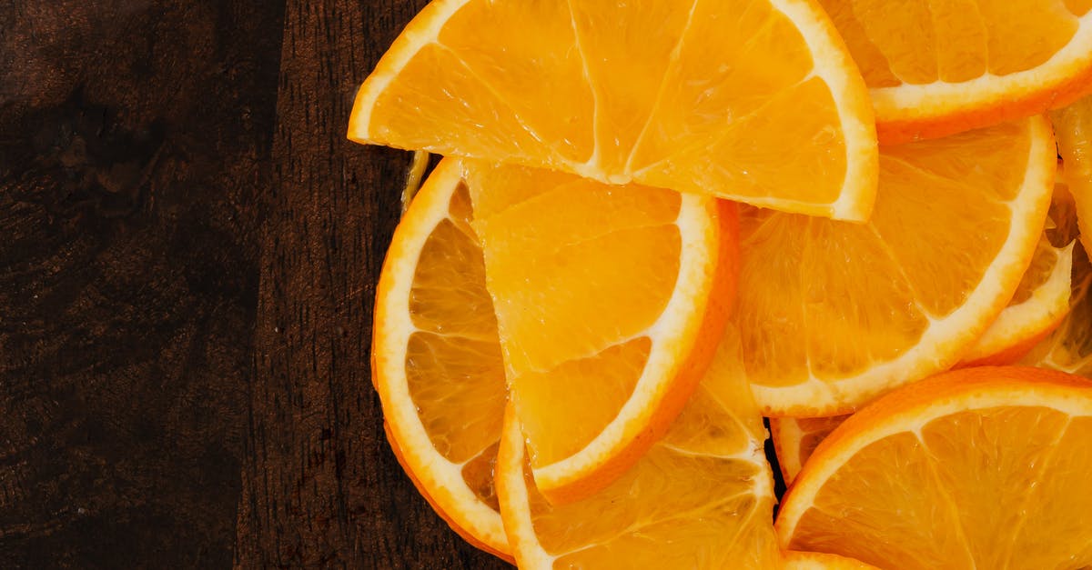 How do you prepare Jello with fruit pieces? - Top view slices of fresh oranges on wooden background