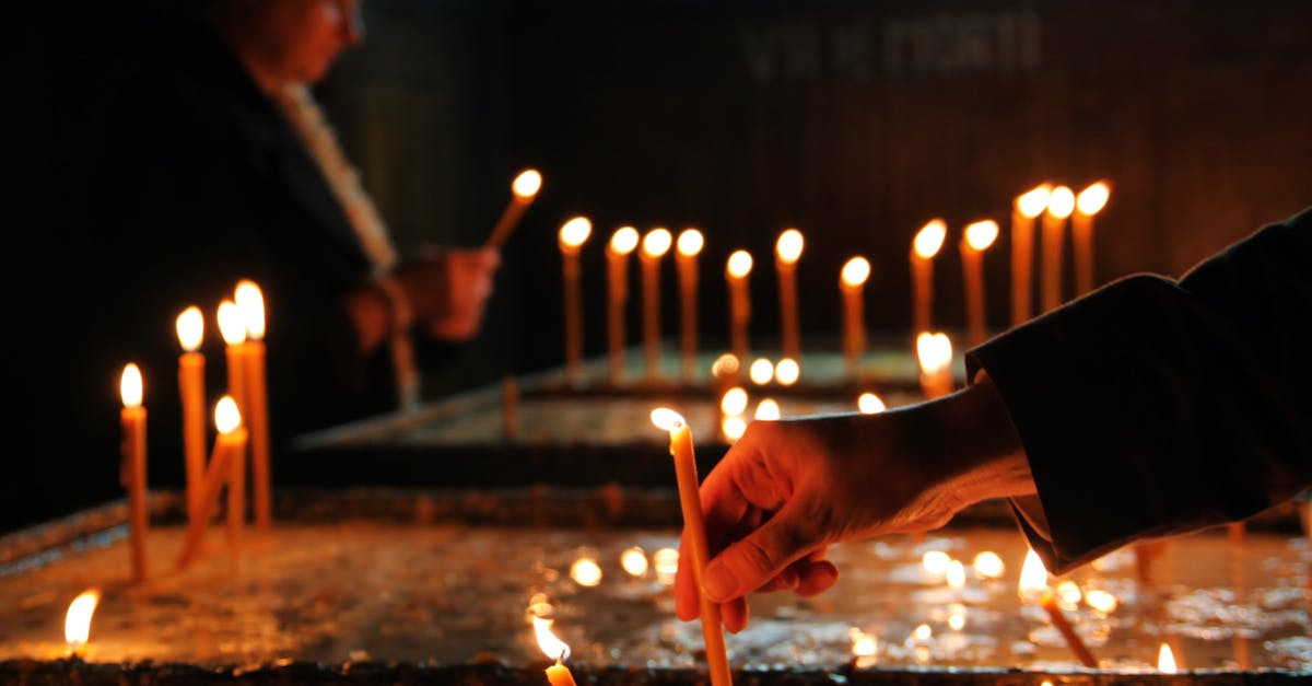 How do you put out a grease fire? - Crop person putting candle in church