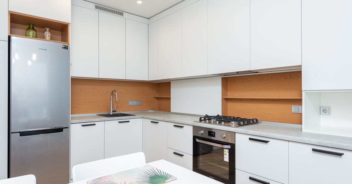 How do you "season" your oven racks? - Contemporary kitchen with gas stove and oven against table with placemats and refrigerator reflecting shiny lamps in house