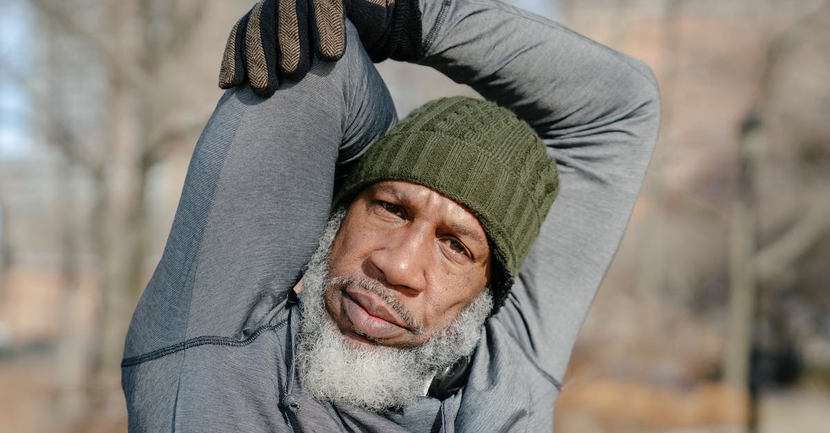 How do you raise your dough in cold seasons? - Black elderly male stretching arms in park in autumn